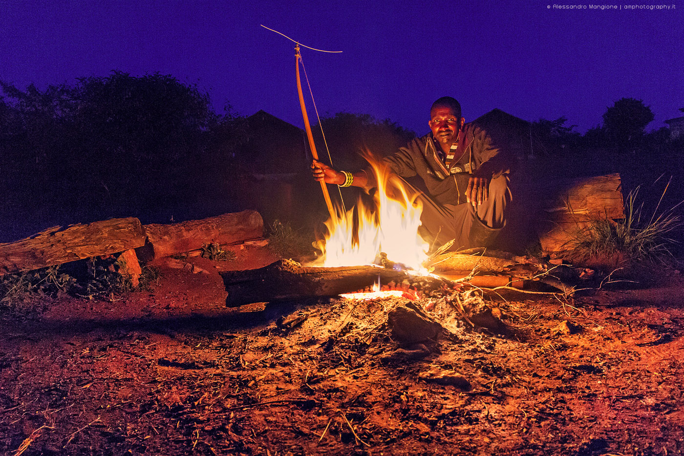 Maasai sit around camp fire